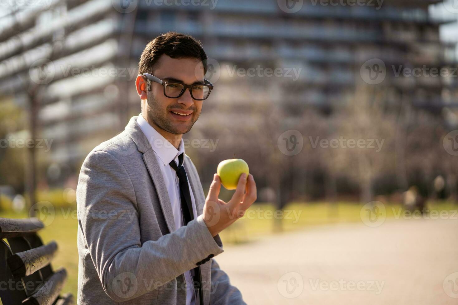 A businessman sitting on a park bench photo