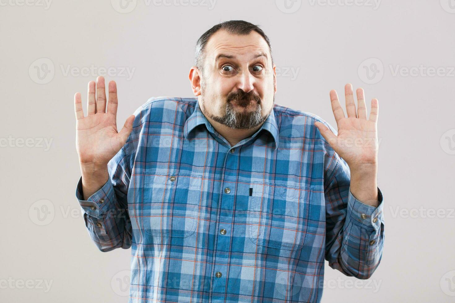 un hombre con un azul tartán camisa haciendo un cara foto