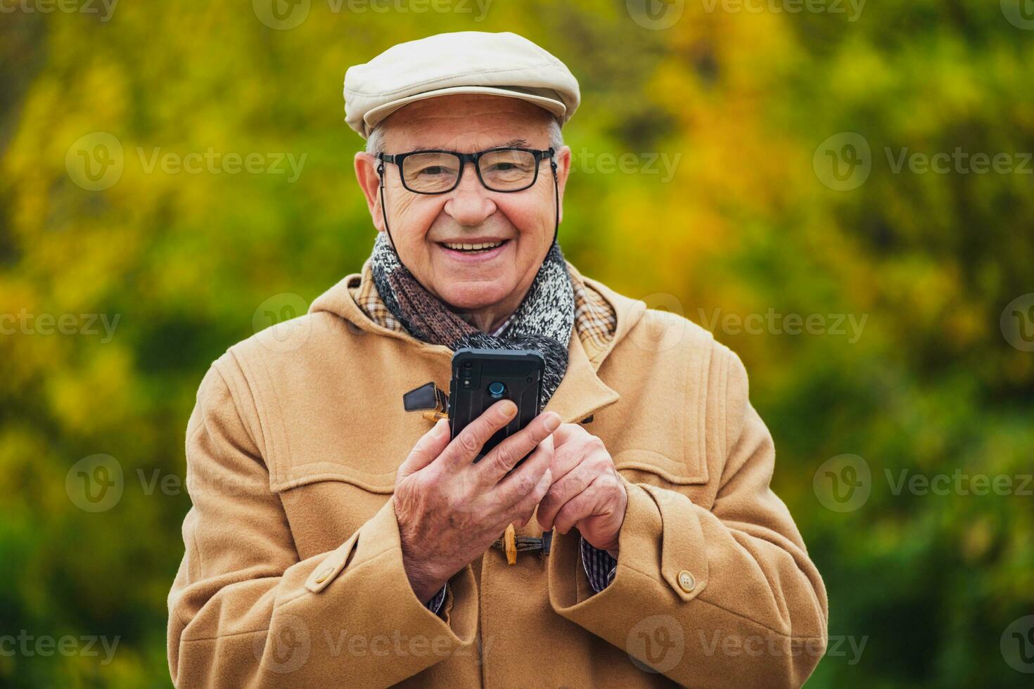 Outdoor portrait of a senior man checking his phone photo