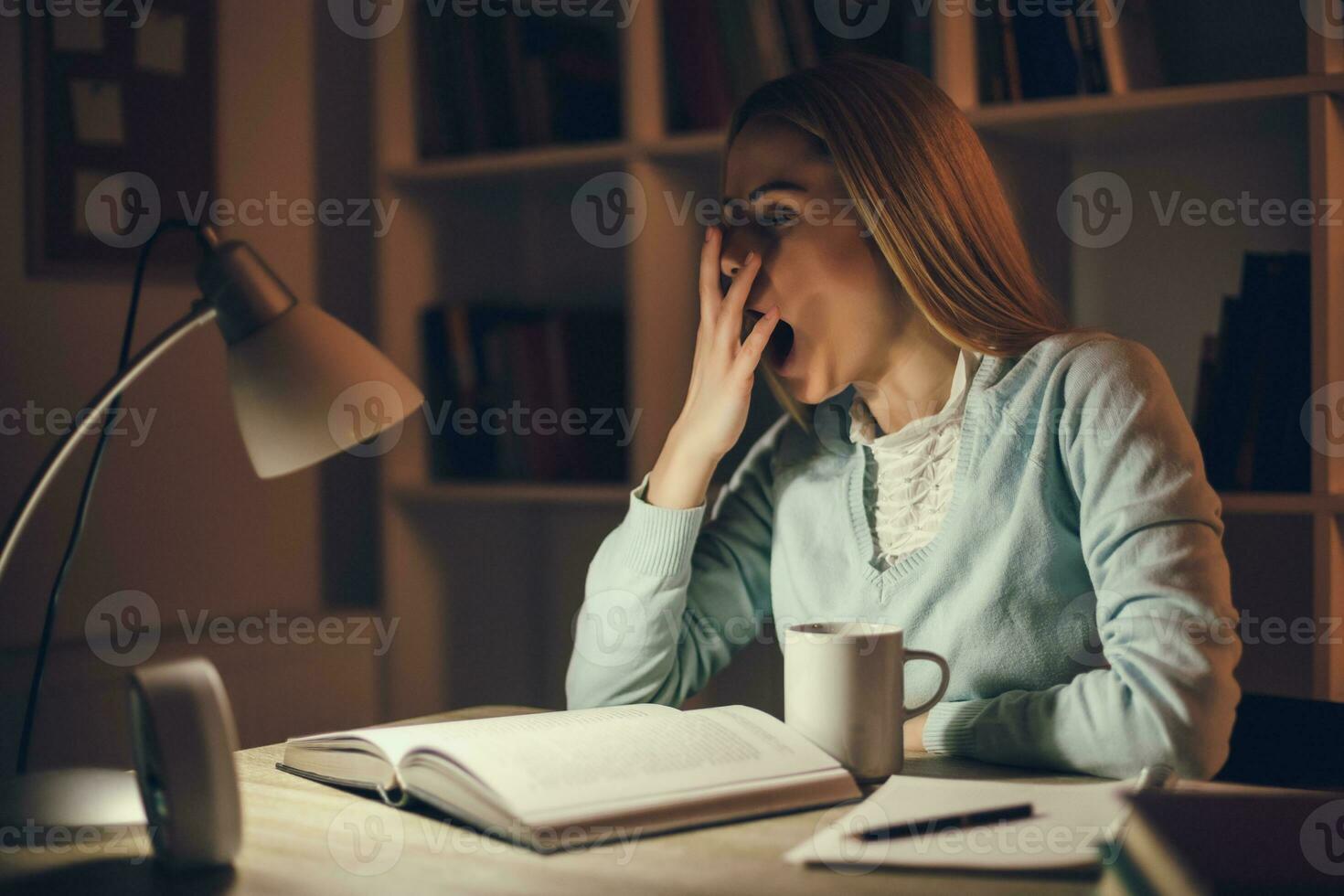 Tired college girl studying late night at home photo