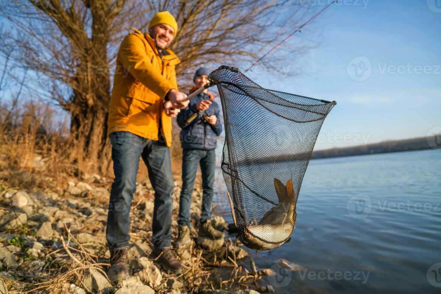 padre y hijo son pescar en soleado invierno día foto