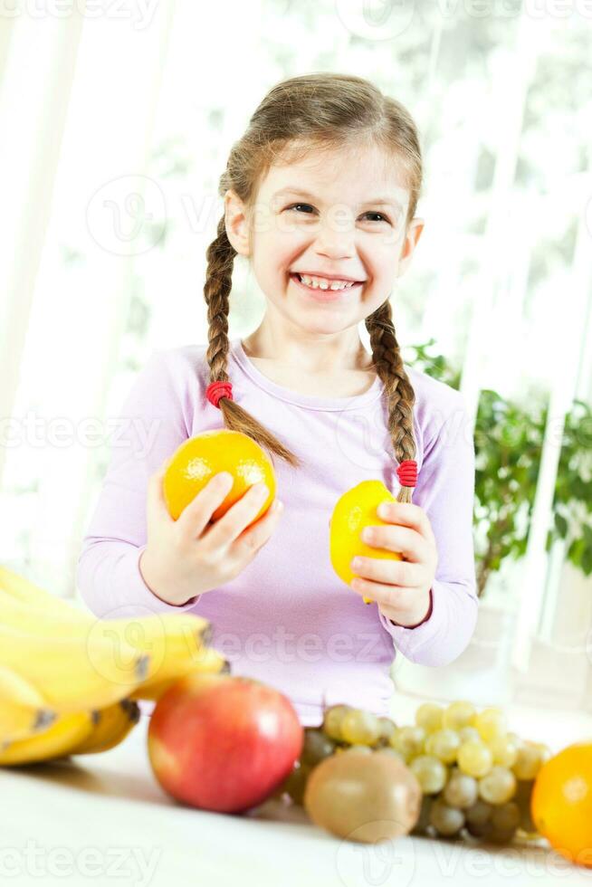 Little girl with fruits for health and wellness concept photo