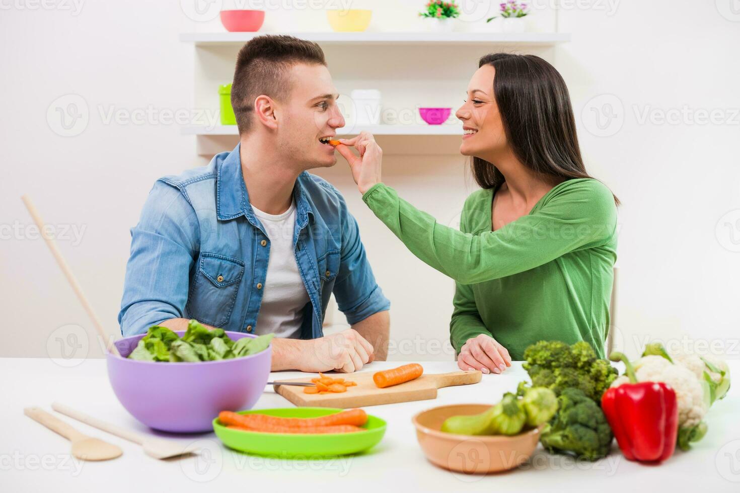 un Pareja teniendo divertido haciendo un ensalada foto