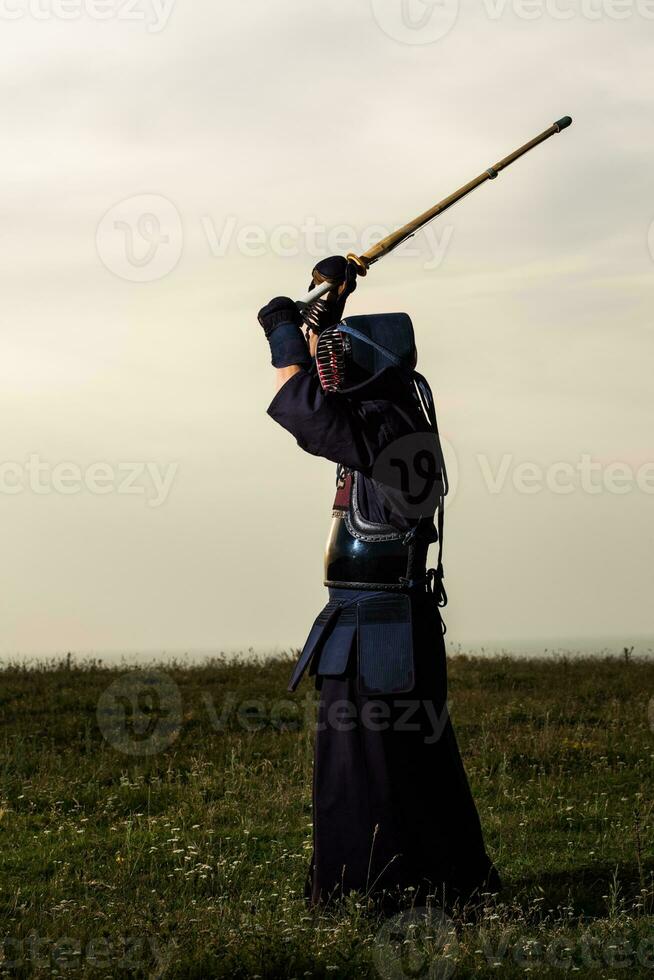 Silhouette of kendo fighter with shinai photo