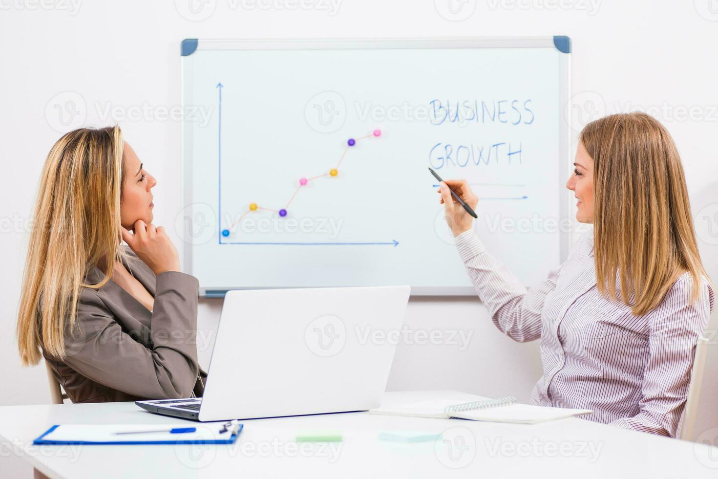 Businesswomen discussing business plan photo