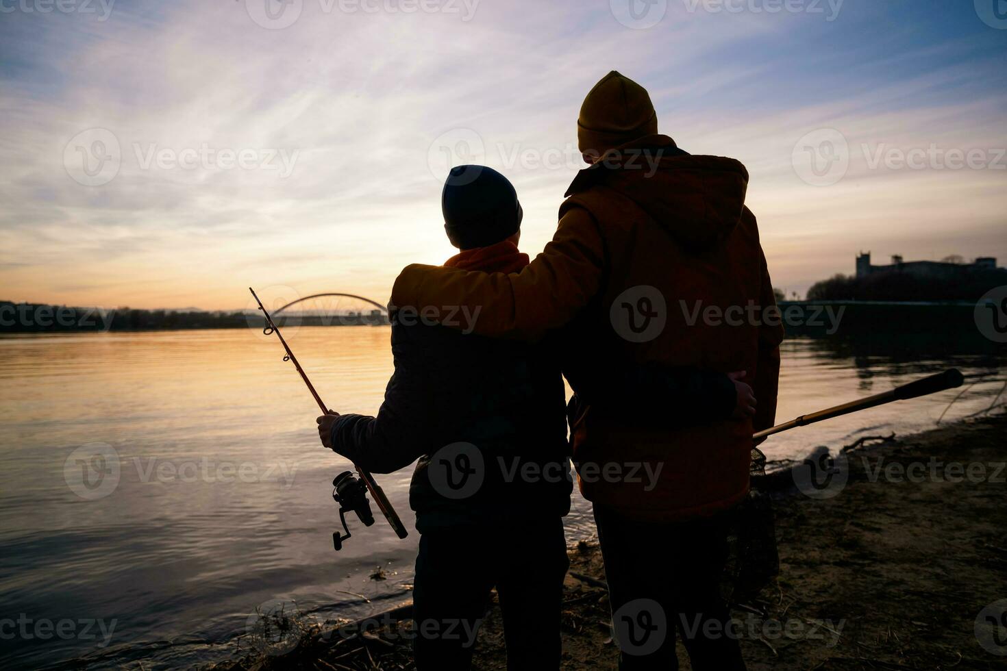 Father and son are fishing on sunny winter day photo