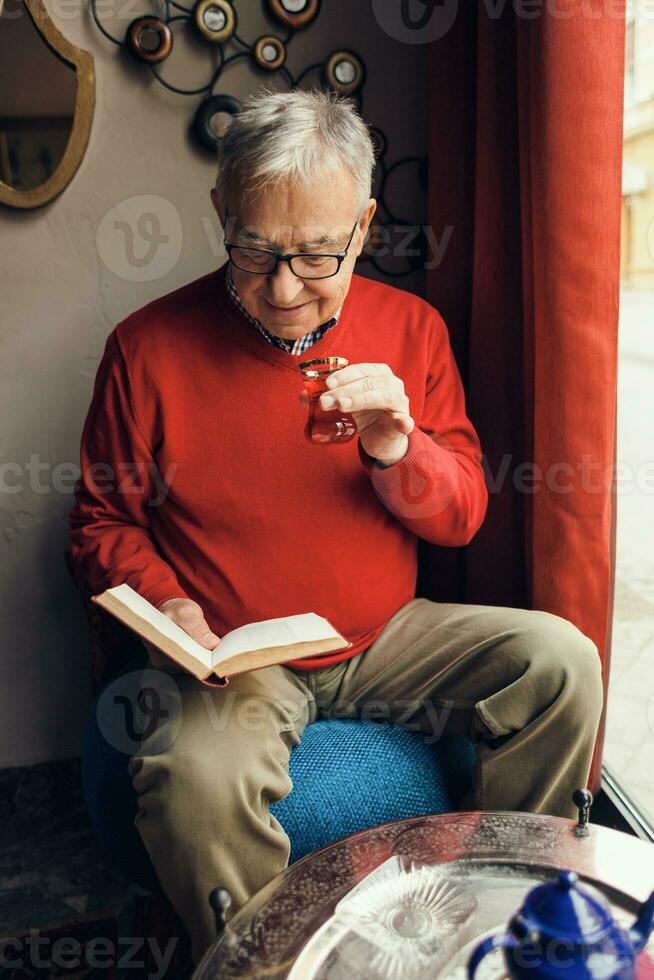 A senior man in a red sweater relaxing photo
