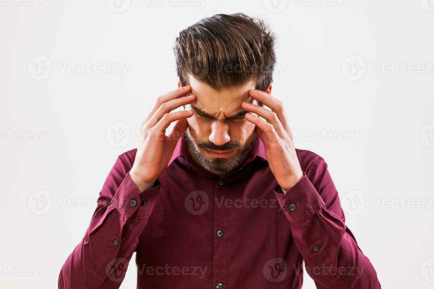 A man in a purple shirt with a headache photo