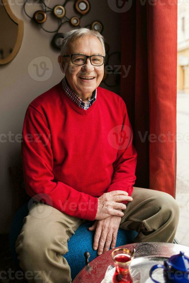 A senior man in a red sweater relaxing photo