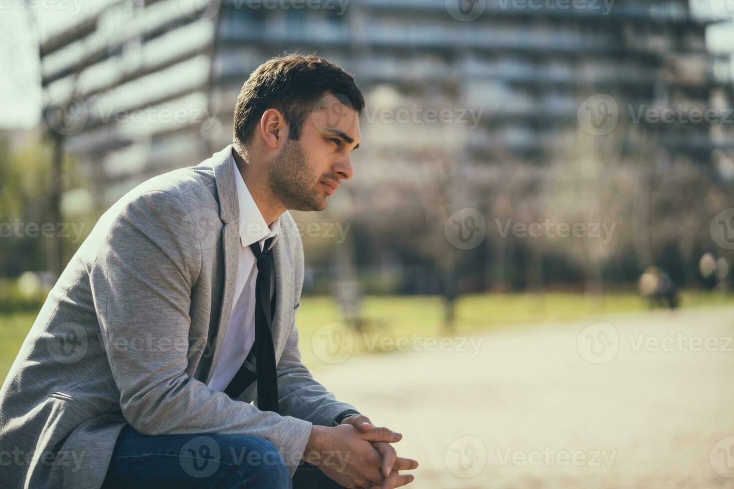 un empresario sentado en un parque banco foto