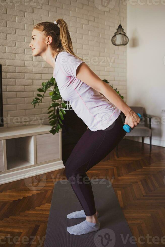 joven mujer haciendo físico ejercicios a hogar foto
