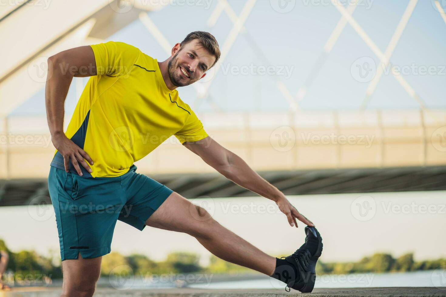 A man in a yellow t-shirt doing physical exercises photo