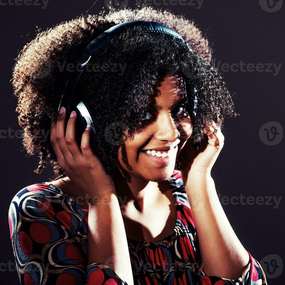retrato de un africano americano mujer escuchando a música foto