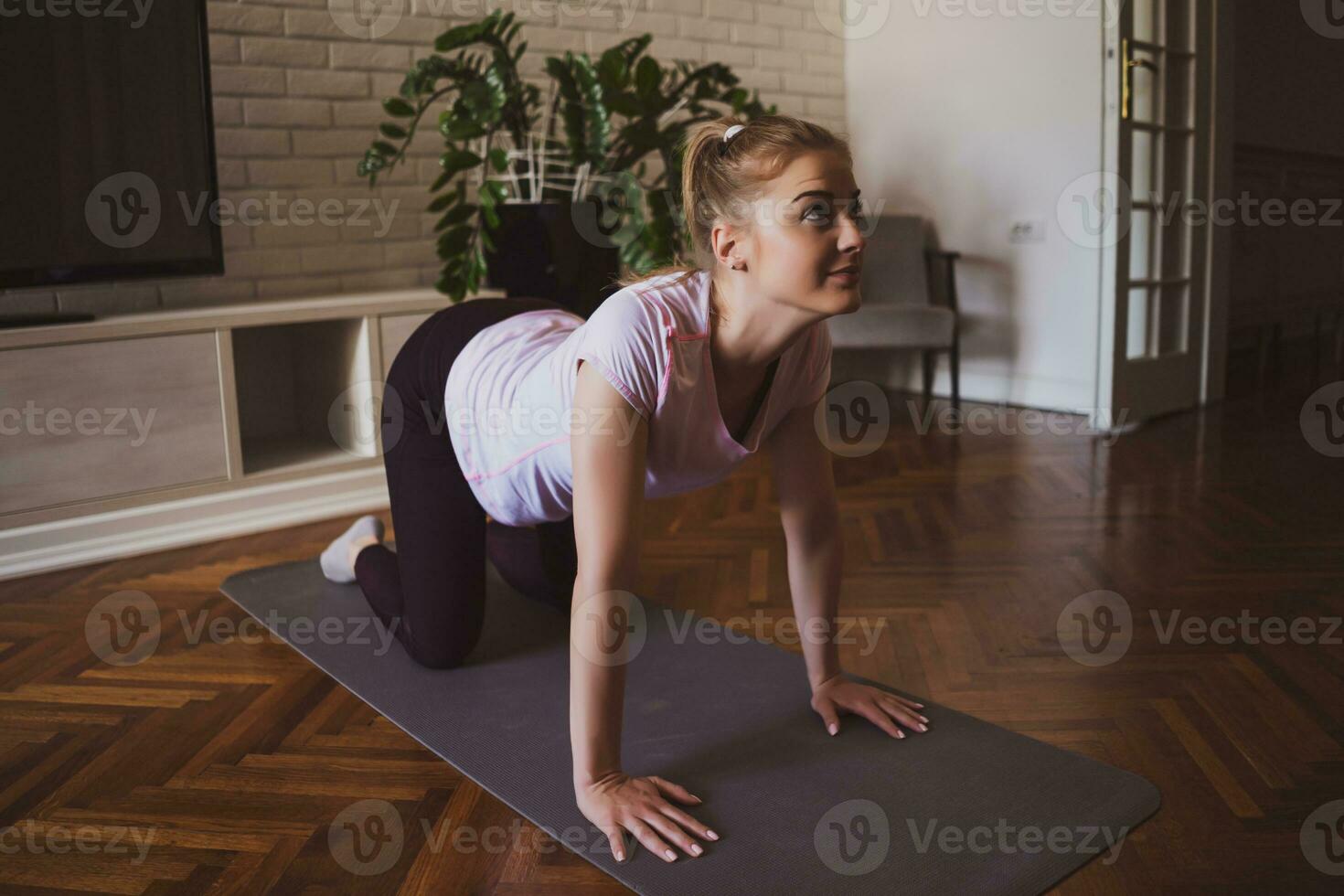 Young woman practicing pilates and yoga exercises at home photo