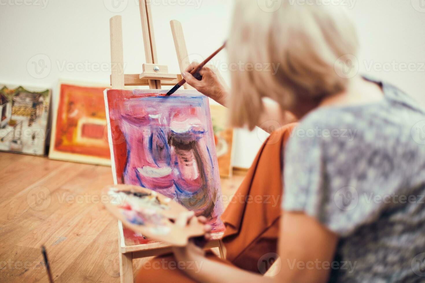 A senior woman painting photo
