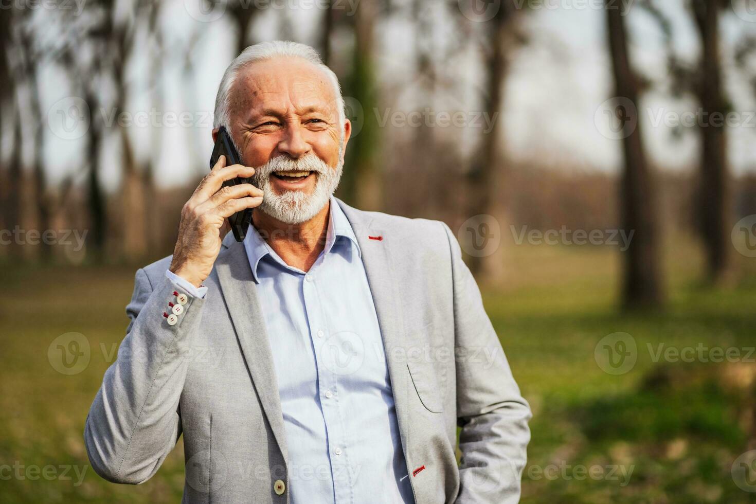 un mayor empresario teniendo un teléfono conversacion foto