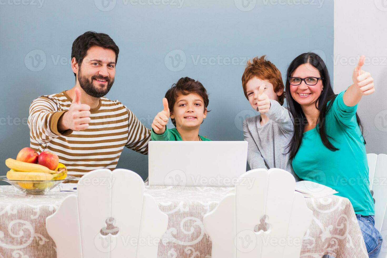 padres son enseñando su niños a utilizar el ordenador portátil foto