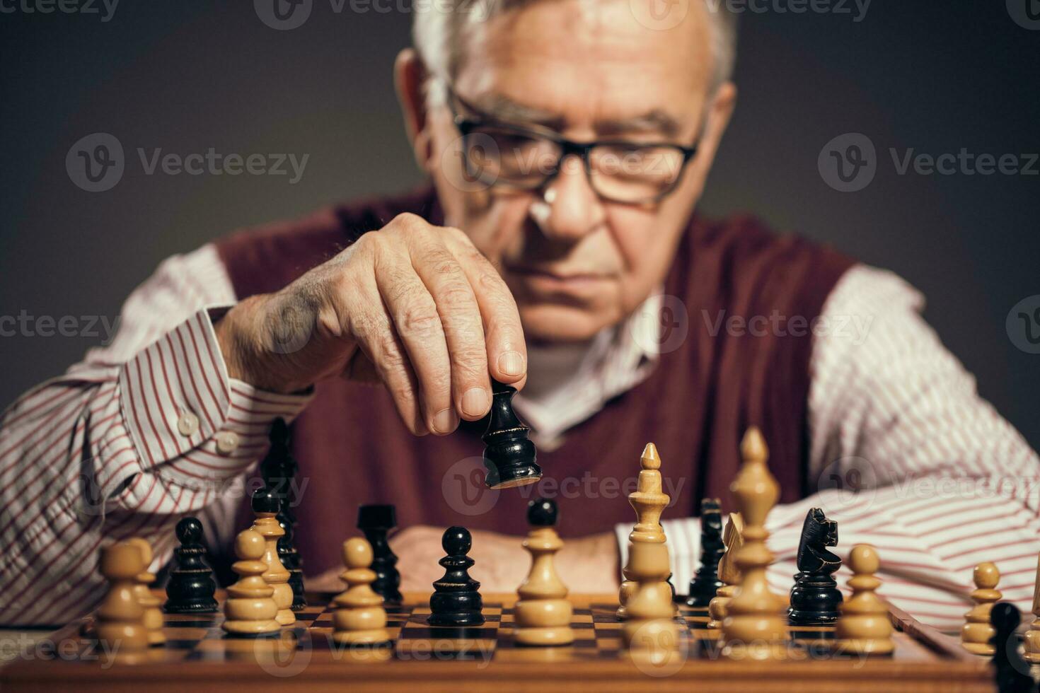 A senior man playing chess photo