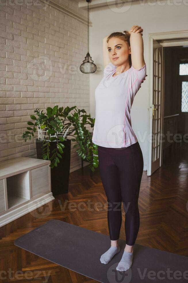 Young woman doing physical exercises at home photo