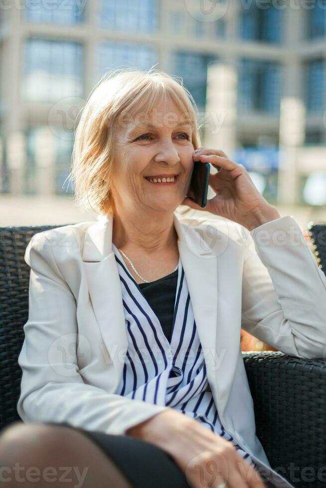 A senior businesswoman sitting at a cafe photo