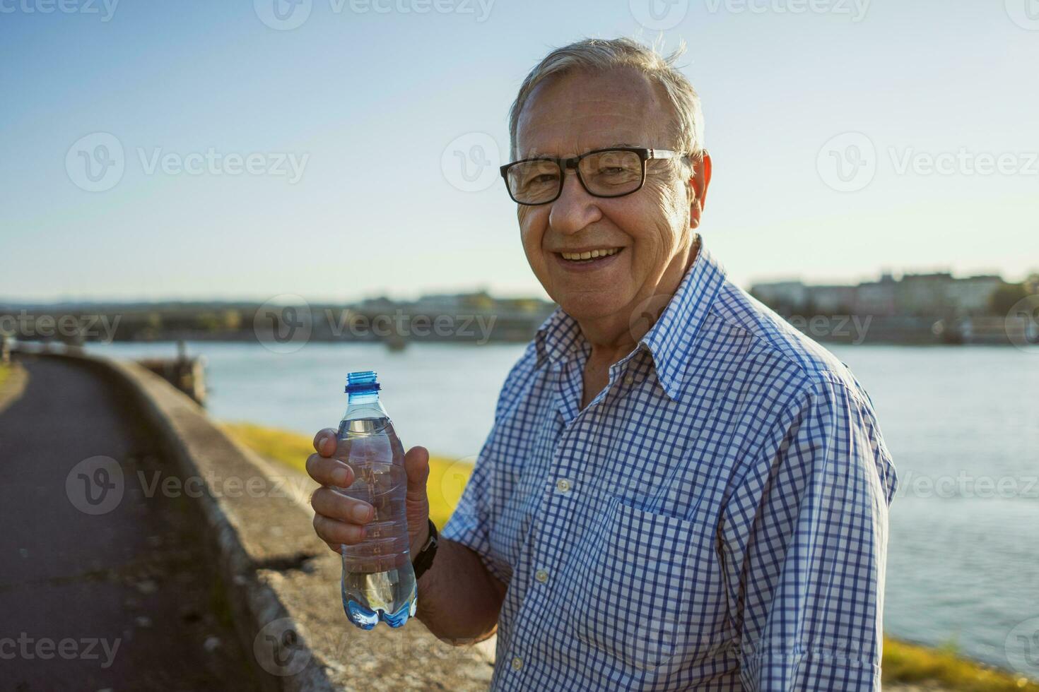 Senior man drinking water outdoors photo