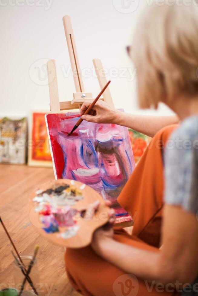 A senior woman painting photo