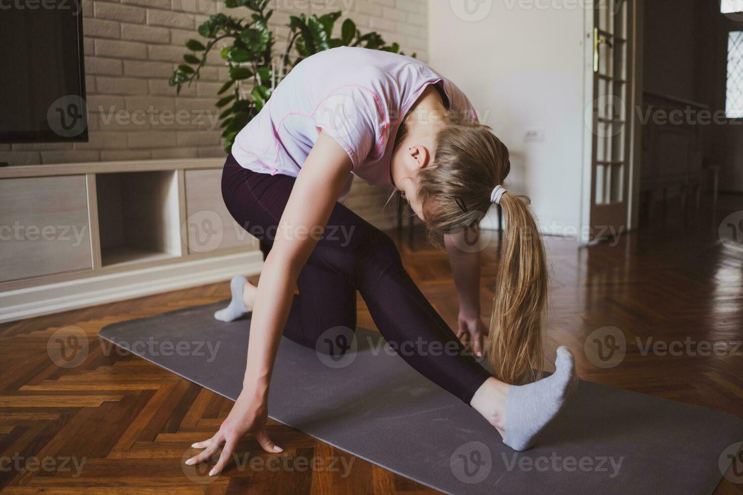 joven mujer practicando pilates y yoga ejercicios a hogar foto