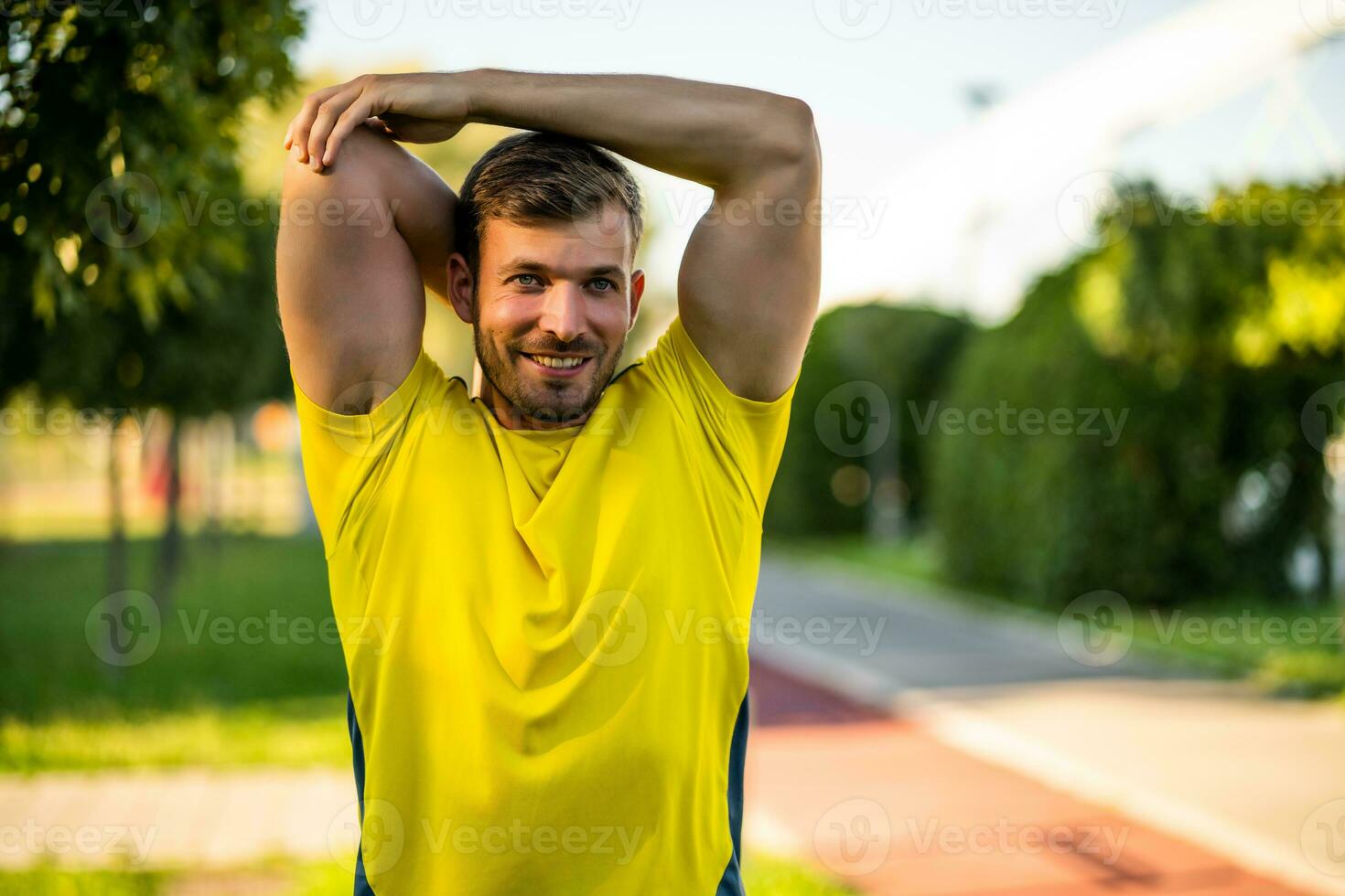 A man in a yellow t-shirt doing physical exercises photo