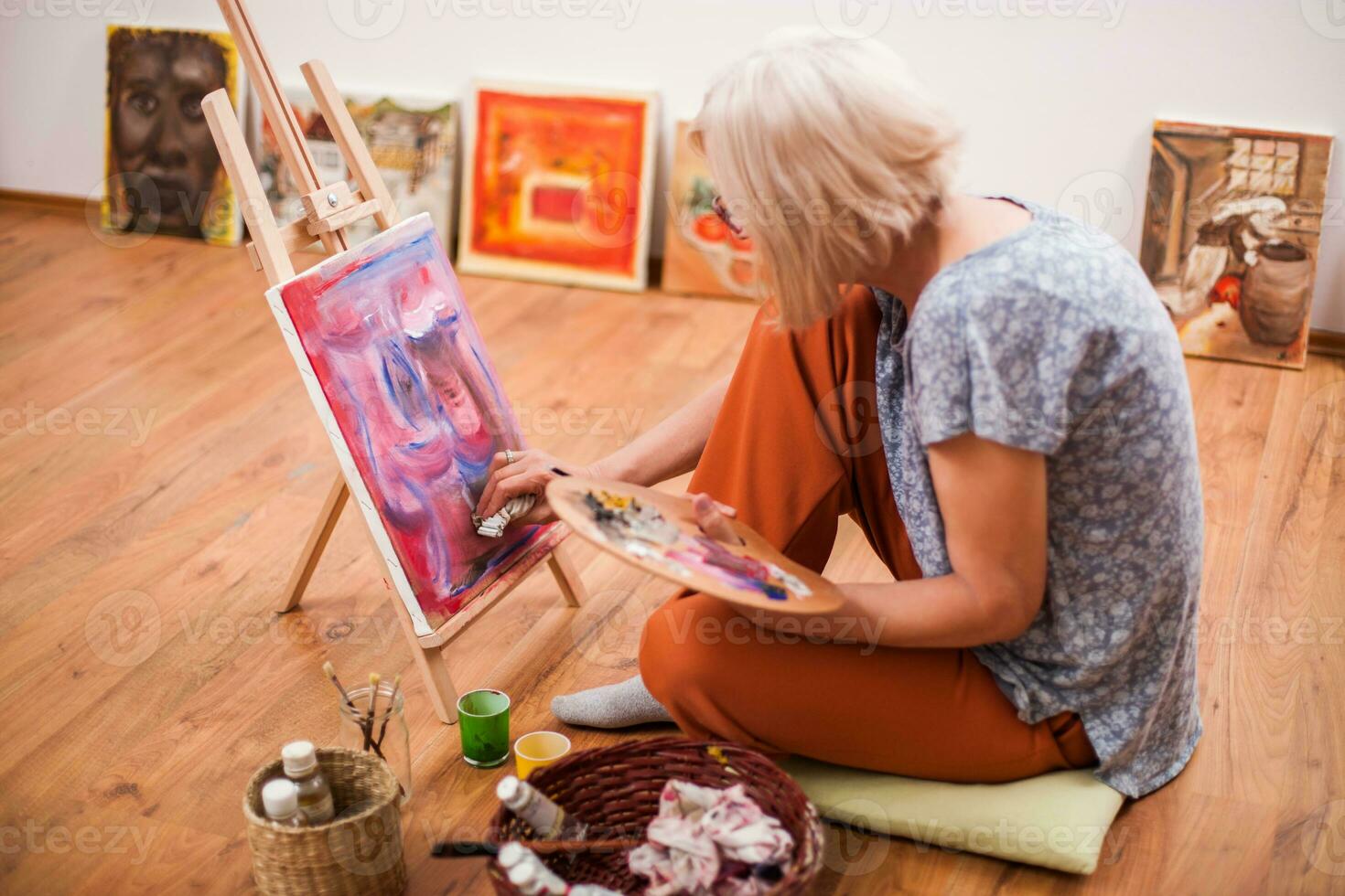 A senior woman painting photo