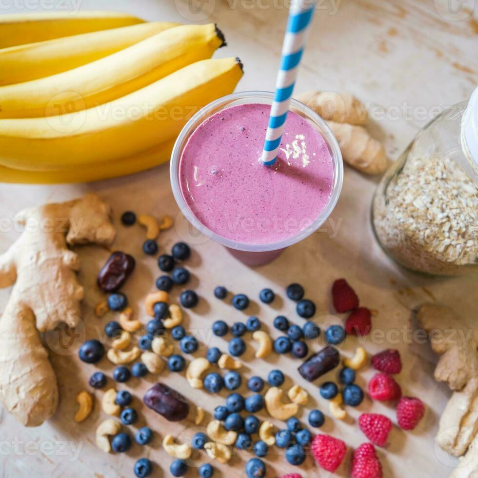 Healthy protein shake on table with fruits and vegetables ingredients around photo