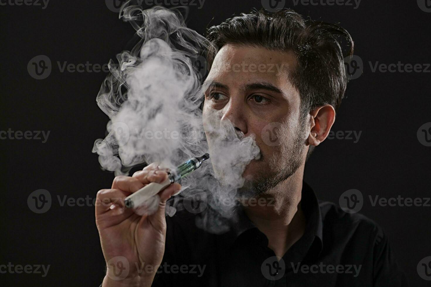 un hombre de fumar un electrónico cigarrillo foto