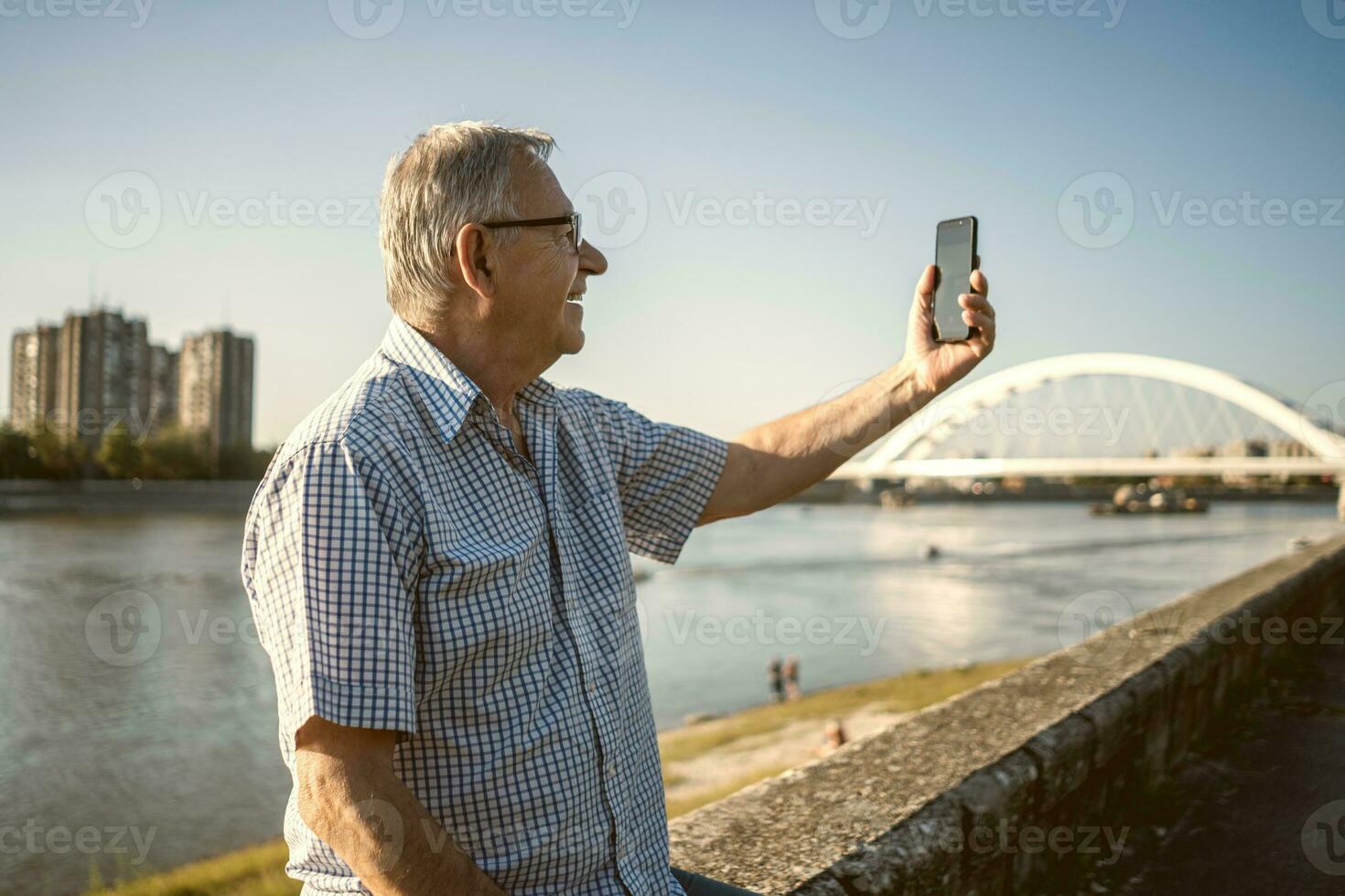 Senior man holding the phone outside photo