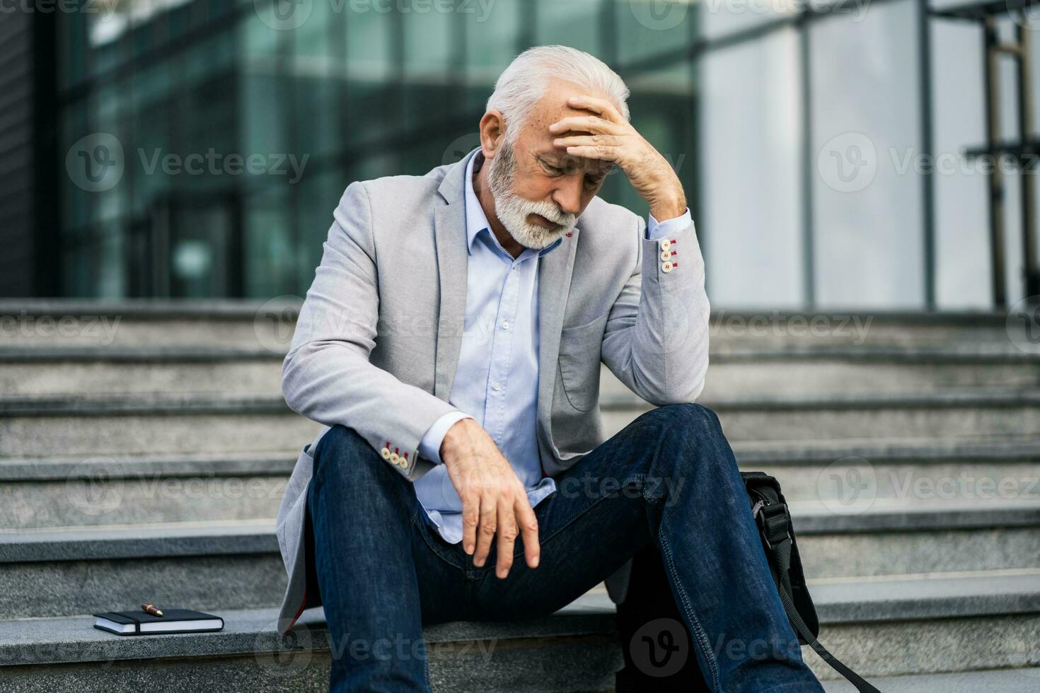 An upset senior man resting on the stairs photo