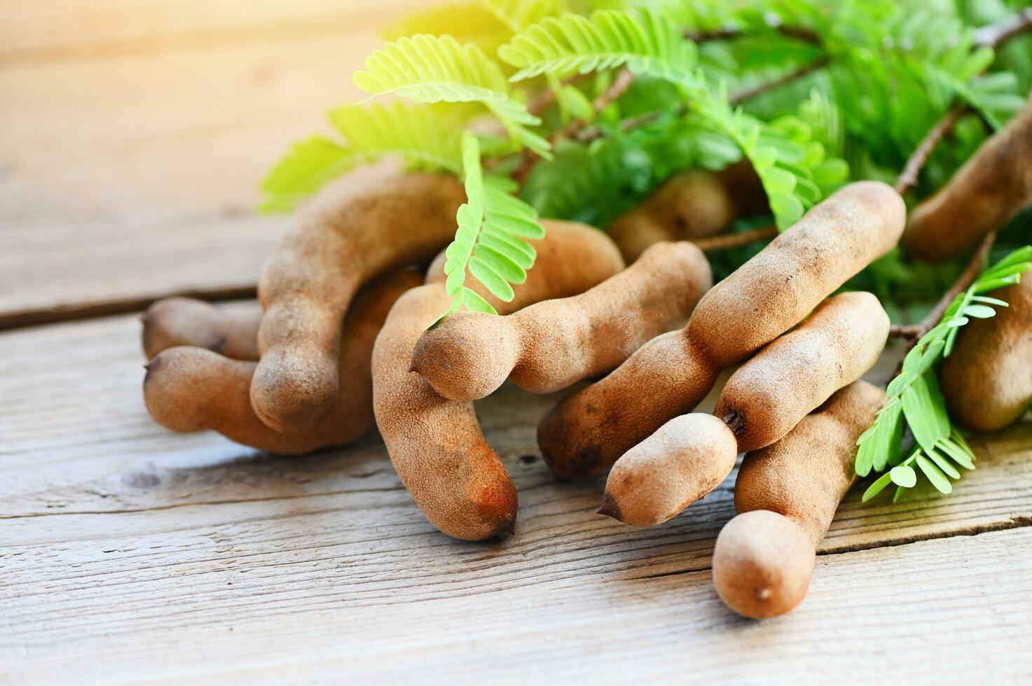 Tamarindo dulce para comida maduro tamarindos en de madera mesa, Tamarindo tropical frutas verano foto