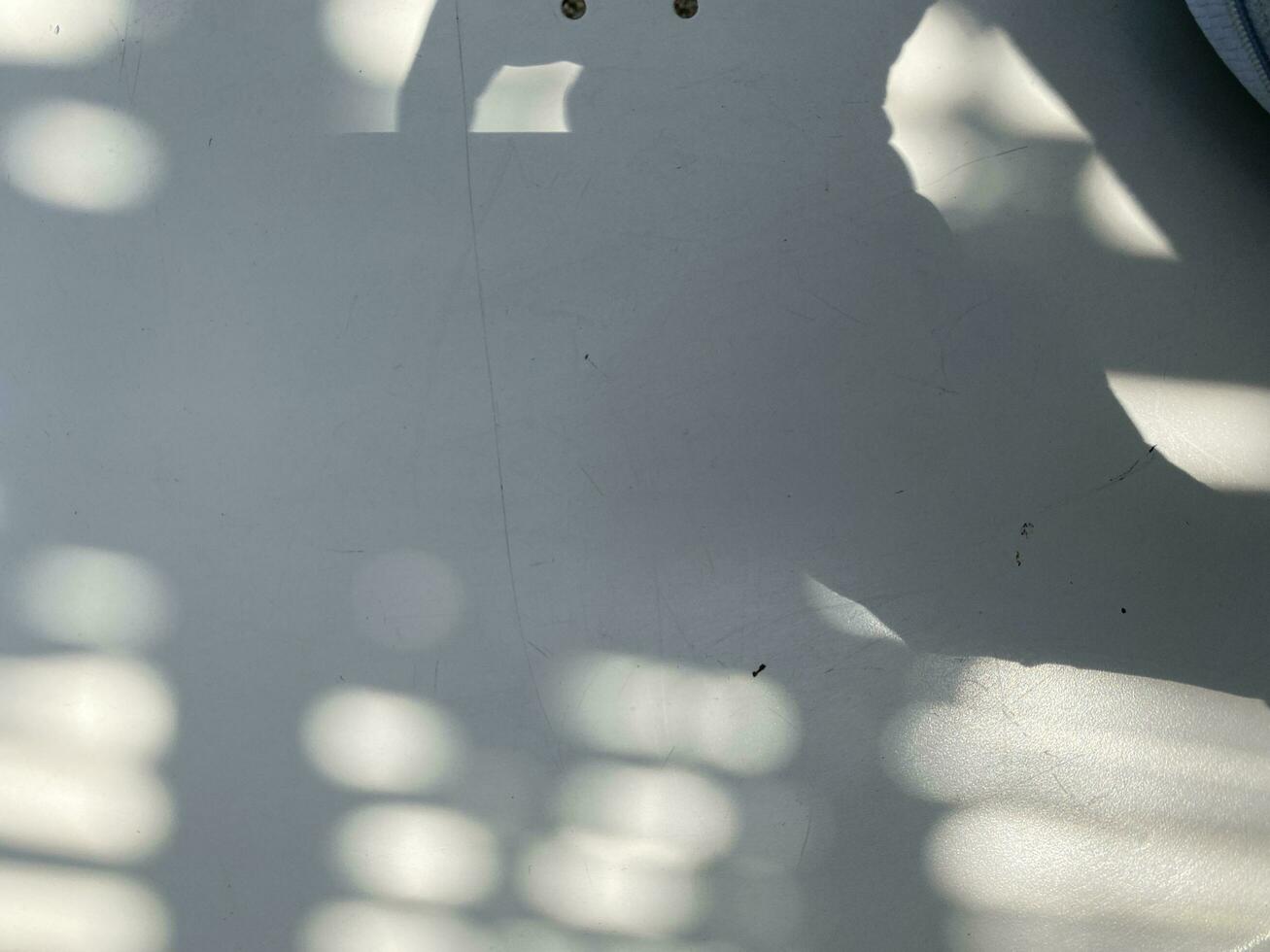 Leaves shadow background on concrete wall texture, leaves tree branches shade with sunlight photo