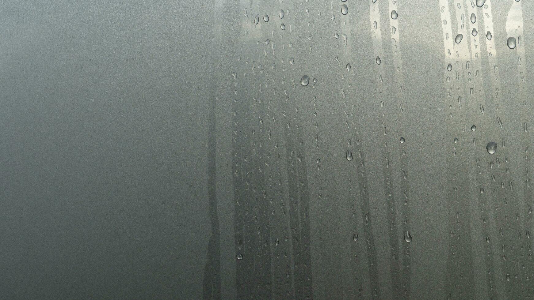 Abstract of Running path of dew drops. On surface gray color body of car. photo