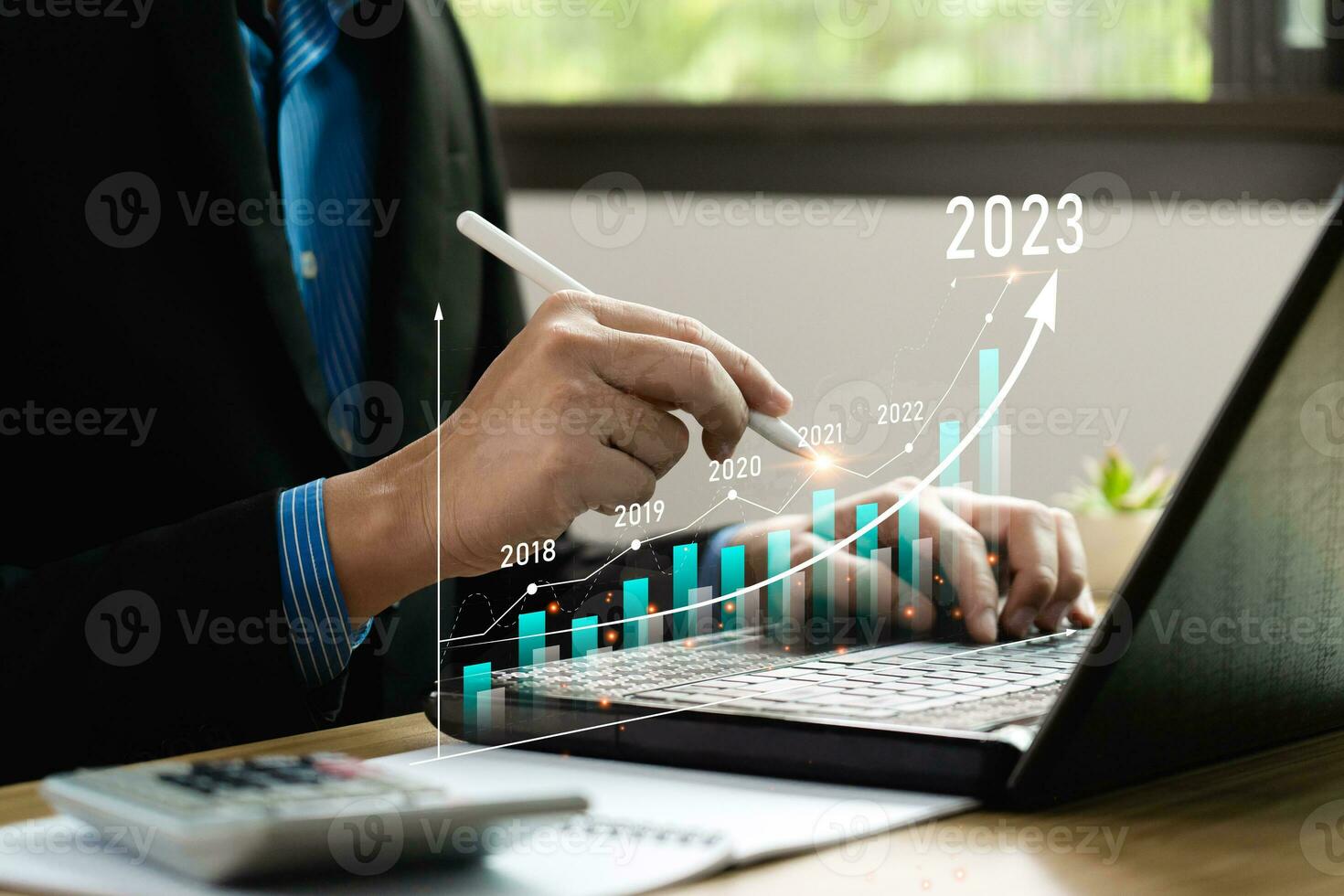 Businessman analyzes profits and plans 2023 business growth with virtual digital graphics. Positive indicators in 2023, businessman calculates financial data for long-term investments.Return on Stocks photo