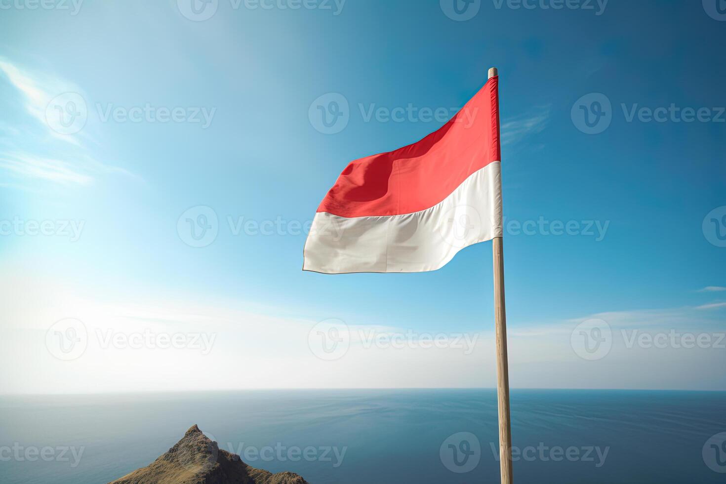 Indonesia national flag waving in the blue sky on the ocean background. Red and white flag with clouds. photo