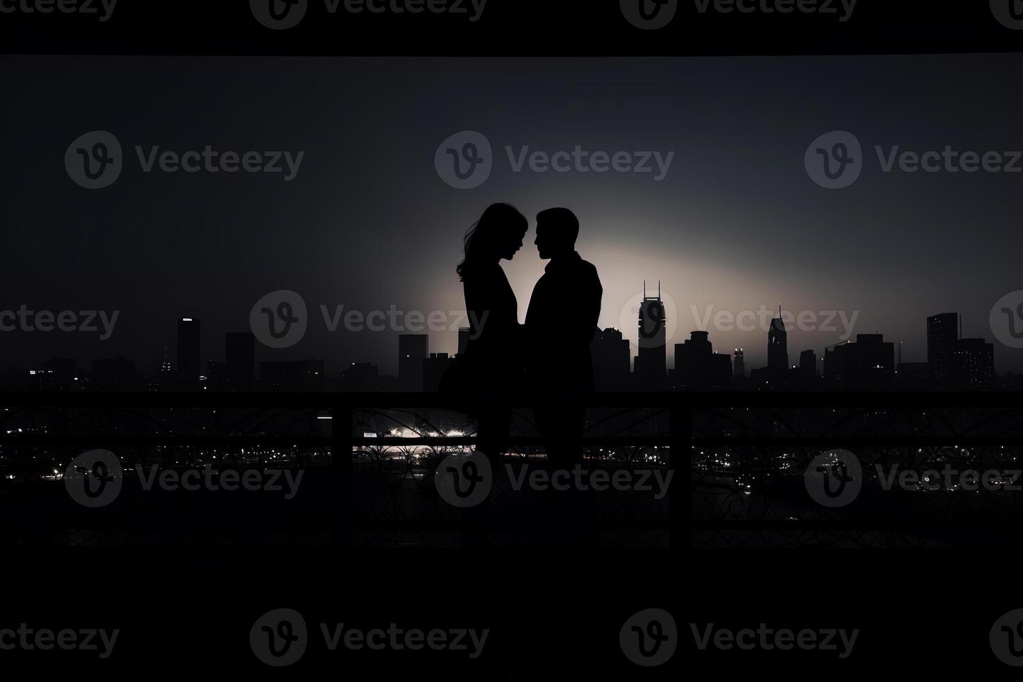 Silhouette of a romantic young couple enjoying the city nightscape. photo