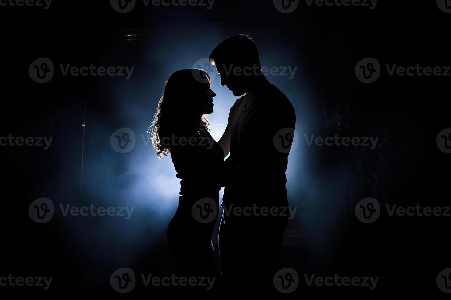 Silhouette of a romantic couple dancing and enjoying in the dark. photo