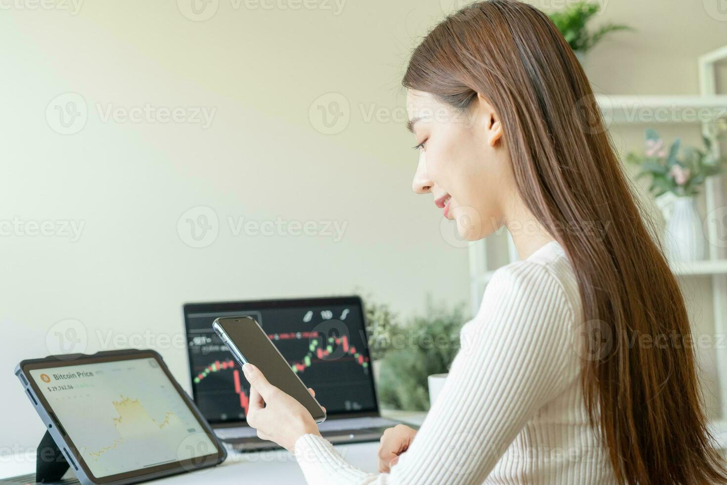 Investor analyzing exchange market, asian young business woman trader on graphic charts on laptop computer, hand in using smartphone for trading stock, looking at screen with diagrams at home office. photo