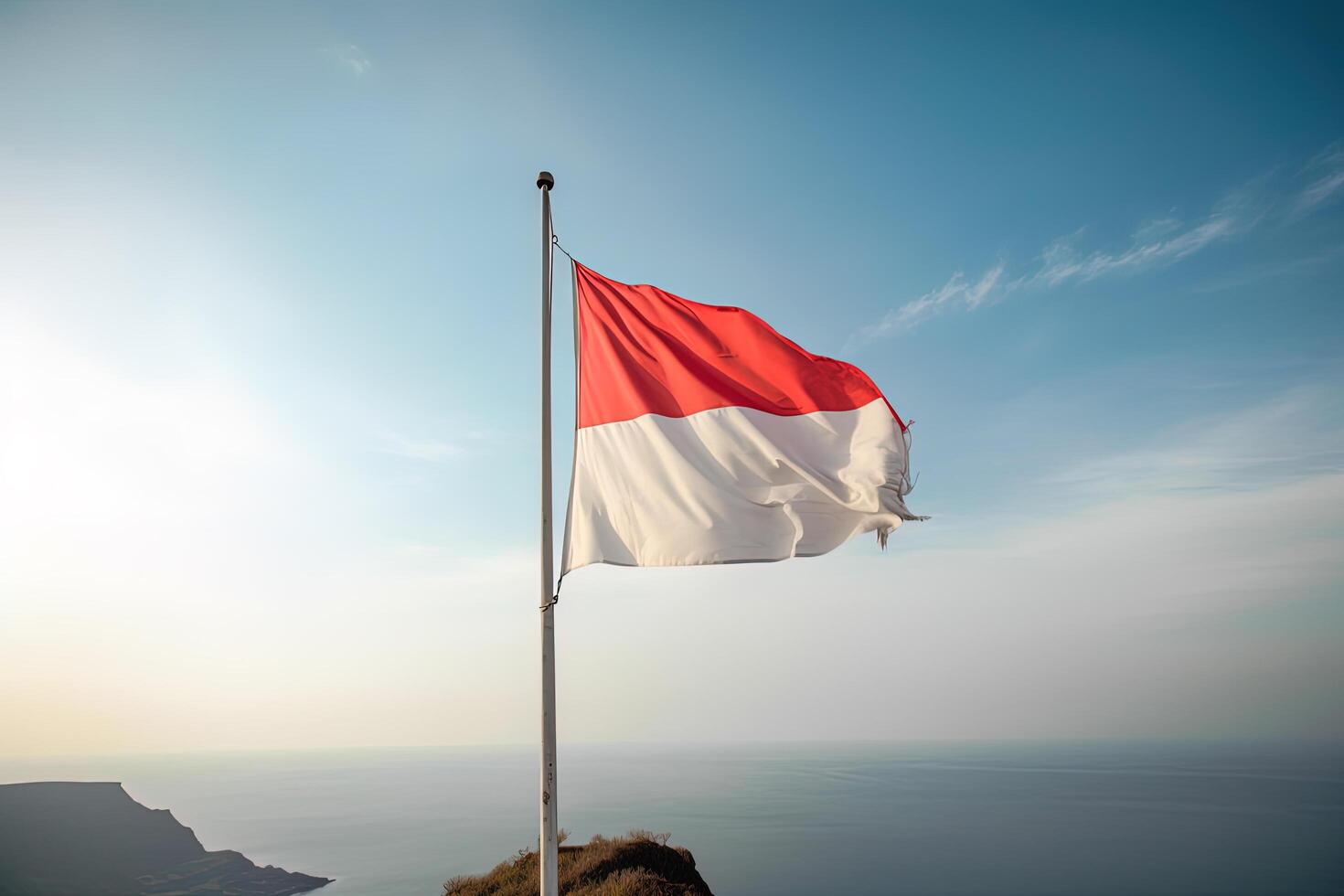 Indonesia national flag waving in the blue sky on the ocean background. Red and white flag with clouds. photo