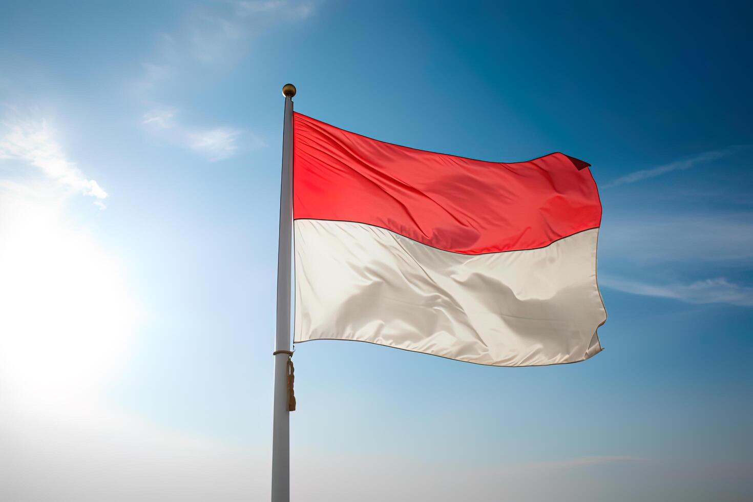 Indonesia national flag waving in blue sky. Red and white flag with clouds. photo