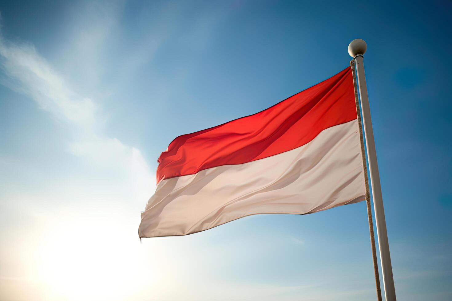 Indonesia national flag waving in blue sky. Red and white flag with clouds. photo