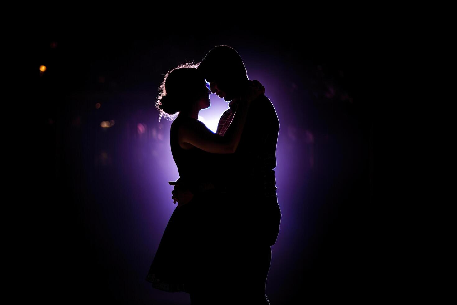 Silhouette of a romantic couple dancing and enjoying in the dark. photo