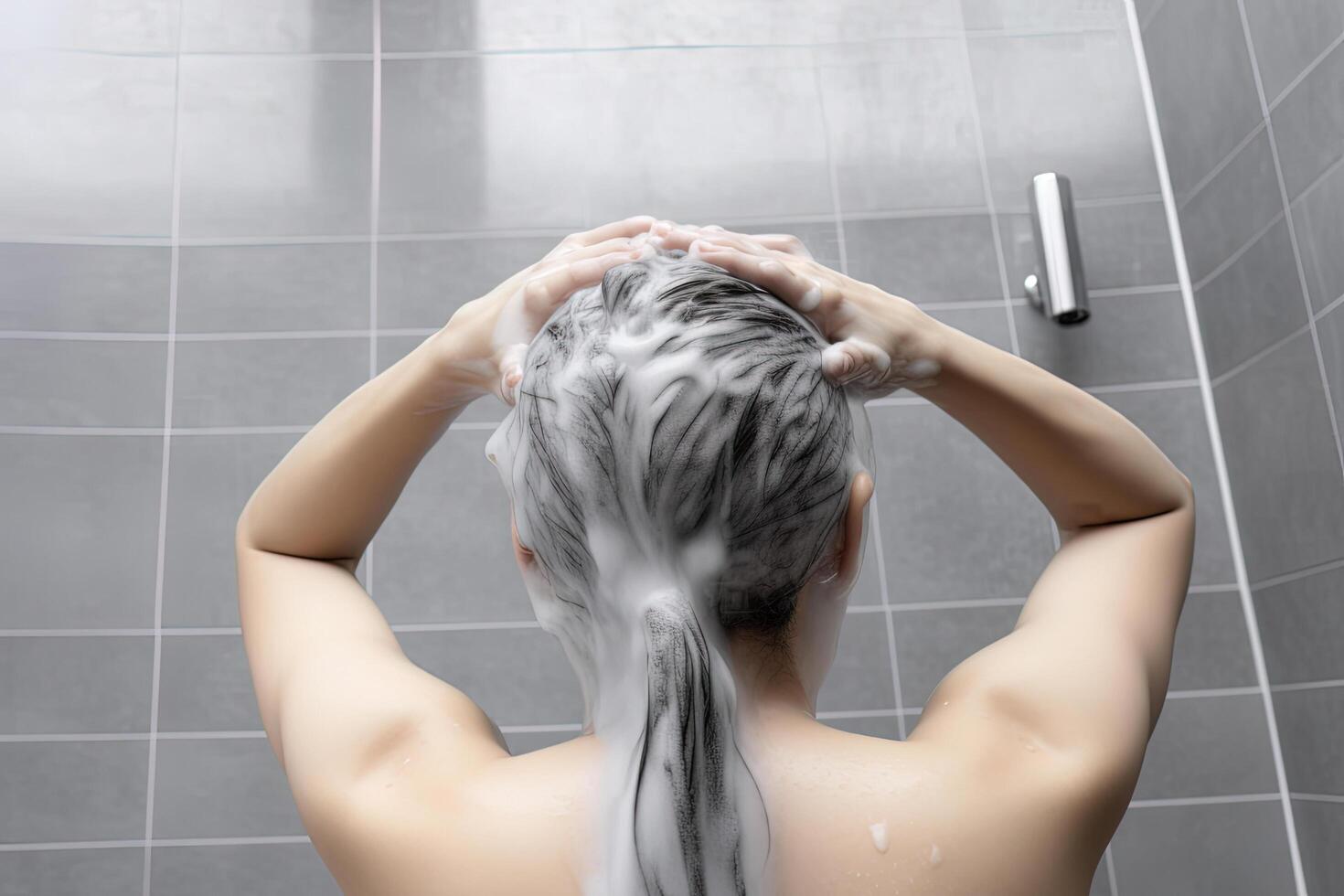 Woman washing hair with shampoo and shower in the bathroom. photo