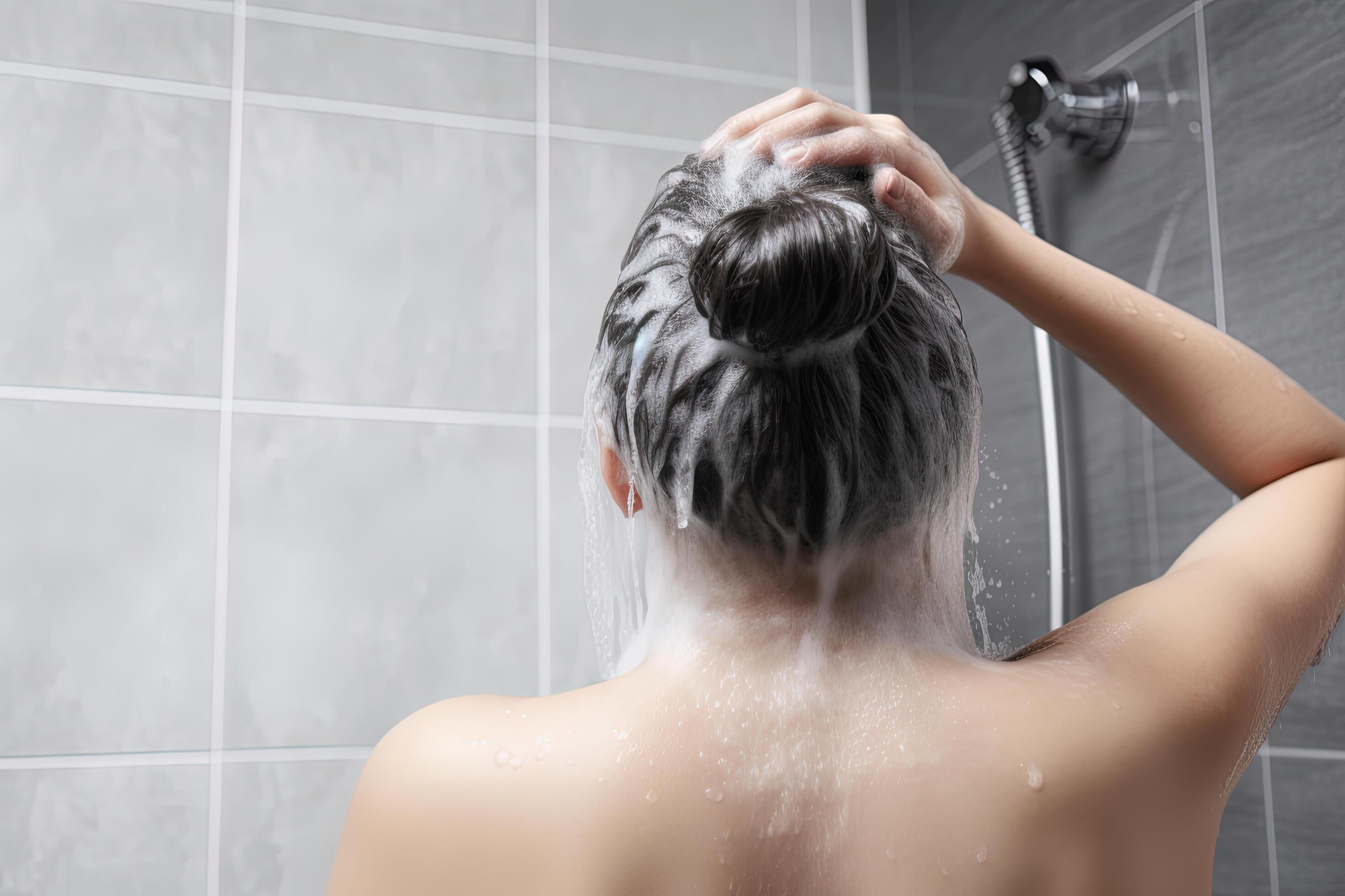 Woman washing hair with shampoo and shower in the bathroom. 23978330
