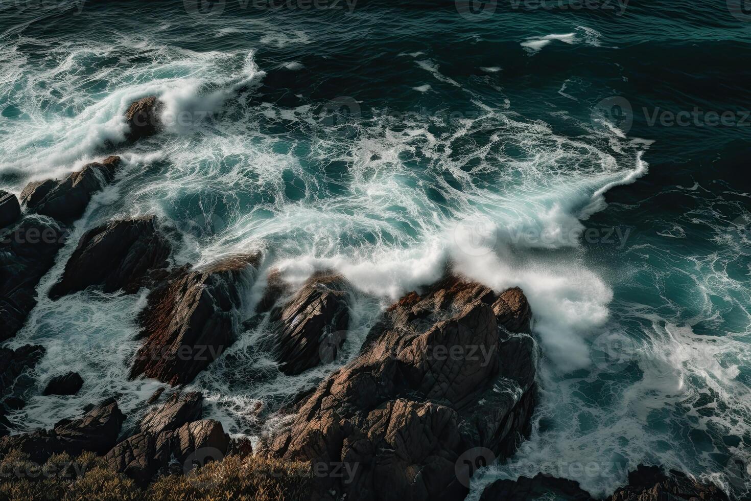 Aerial view of waves crashing against the rocks in the ocean. photo