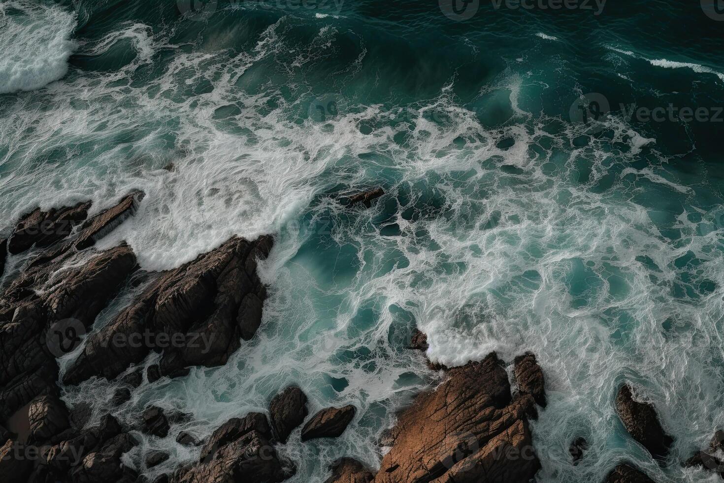 Aerial view of waves crashing against the rocks in the ocean. photo
