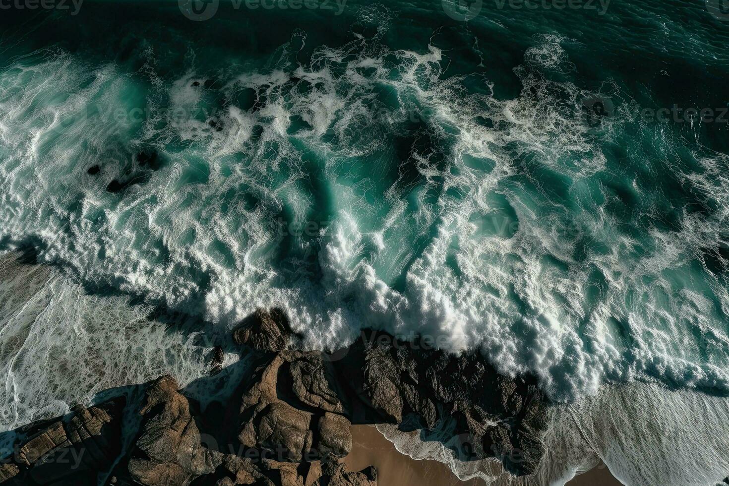 Aerial view of waves crashing against the rocks in the ocean. photo